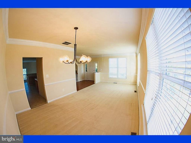 empty room featuring visible vents, baseboards, a chandelier, ornamental molding, and carpet flooring