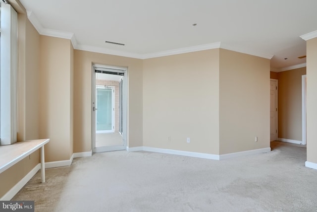 empty room featuring ornamental molding, baseboards, and light colored carpet