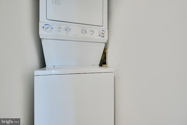 clothes washing area with stacked washer and clothes dryer