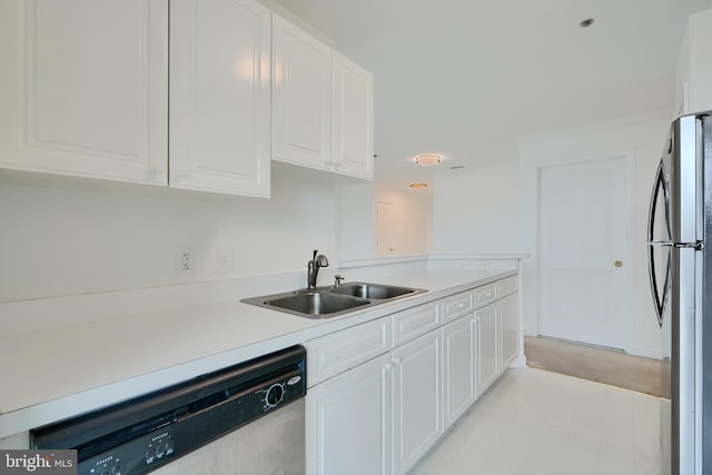 kitchen featuring dishwashing machine, freestanding refrigerator, a sink, white cabinets, and light countertops
