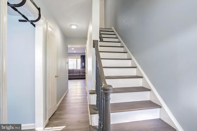 staircase with baseboards and wood finished floors
