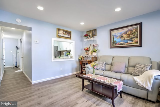 living room with recessed lighting, baseboards, and wood finished floors