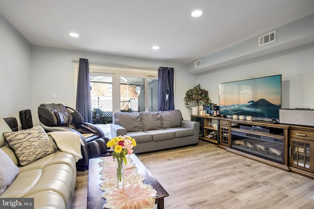 living area with visible vents, recessed lighting, and wood finished floors