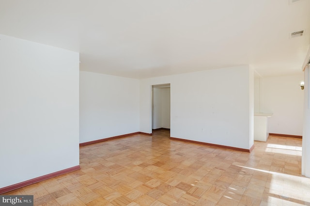 empty room featuring baseboards and visible vents