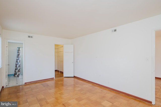 unfurnished room featuring baseboards and visible vents