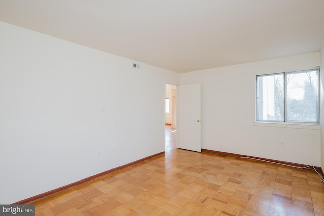 unfurnished room featuring baseboards and visible vents