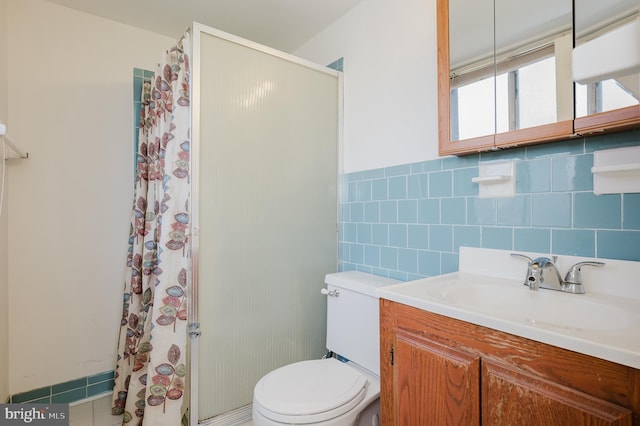 full bathroom featuring tile walls, a shower with shower curtain, toilet, vanity, and wainscoting
