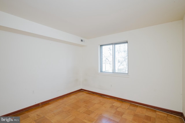 unfurnished room with baseboards and visible vents