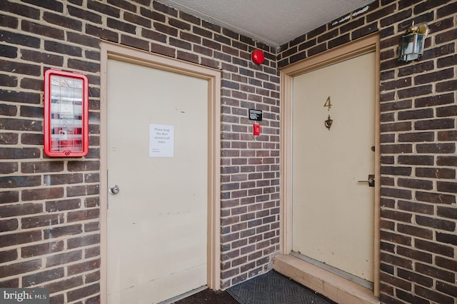 entrance to property featuring brick siding