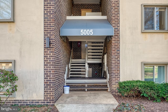 entrance to property featuring brick siding