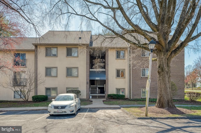 view of building exterior with uncovered parking and stairs