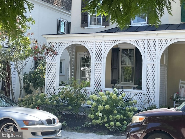 exterior space with a porch and stucco siding