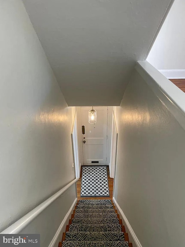 stairs featuring wood finished floors and baseboards