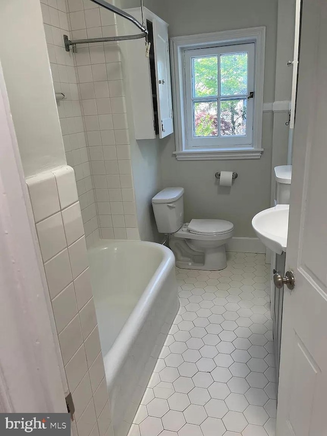 full bathroom with toilet, baseboards, a shower, and a bathtub