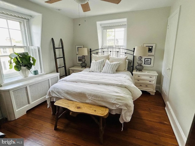 bedroom featuring hardwood / wood-style flooring, radiator, baseboards, and a ceiling fan
