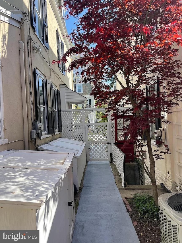 exterior space with cooling unit and stucco siding