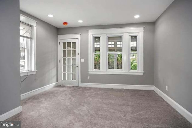 carpeted spare room featuring baseboards and recessed lighting