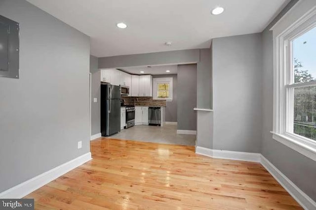 kitchen with baseboards, white cabinetry, stainless steel appliances, and tasteful backsplash