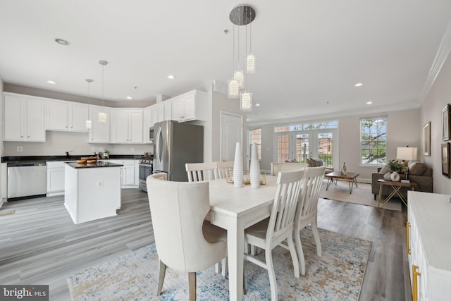 dining area with crown molding, light wood finished floors, and recessed lighting