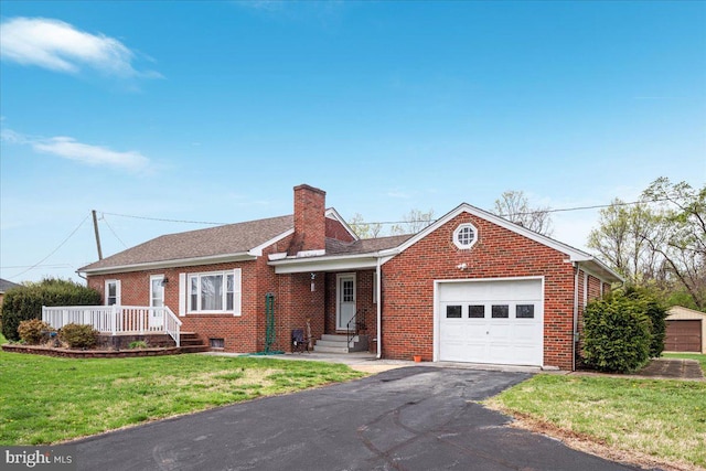 ranch-style house featuring a front yard, an attached garage, a chimney, brick siding, and driveway