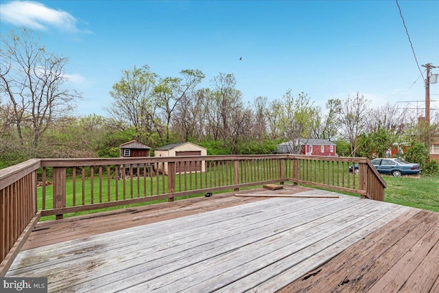 wooden deck with a yard, an outdoor structure, and a storage unit