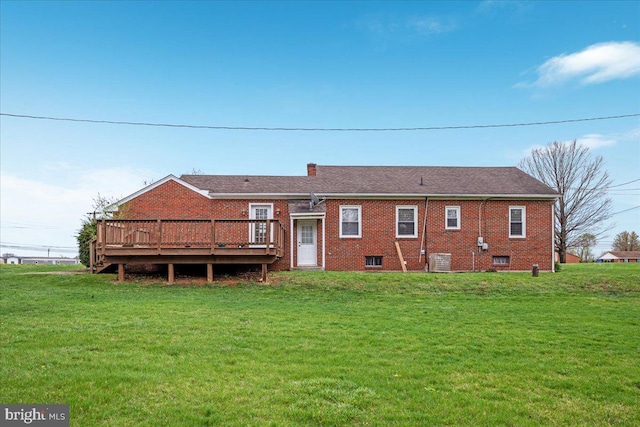 back of property featuring a yard, brick siding, a deck, and central AC