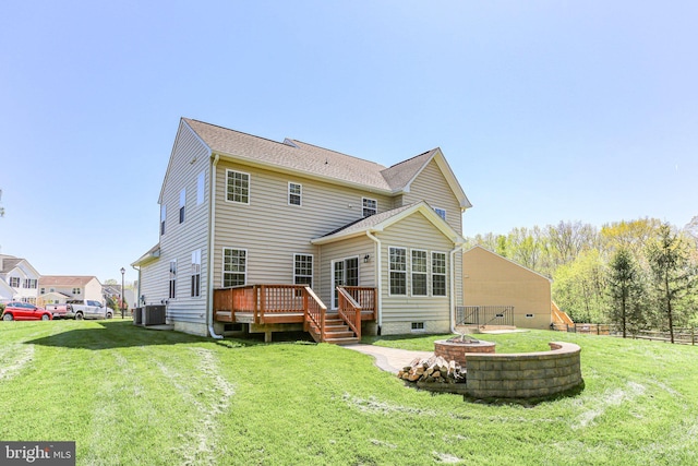 back of property featuring a wooden deck, a fire pit, a lawn, and cooling unit