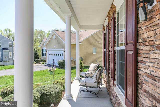view of patio / terrace with aphalt driveway and a porch