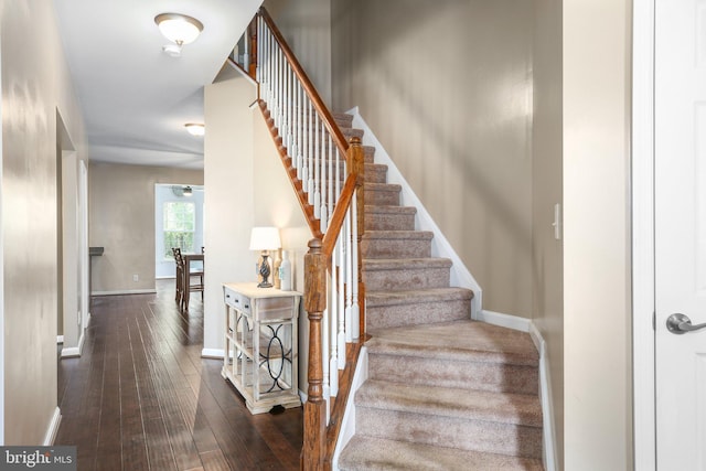 stairway featuring hardwood / wood-style flooring and baseboards