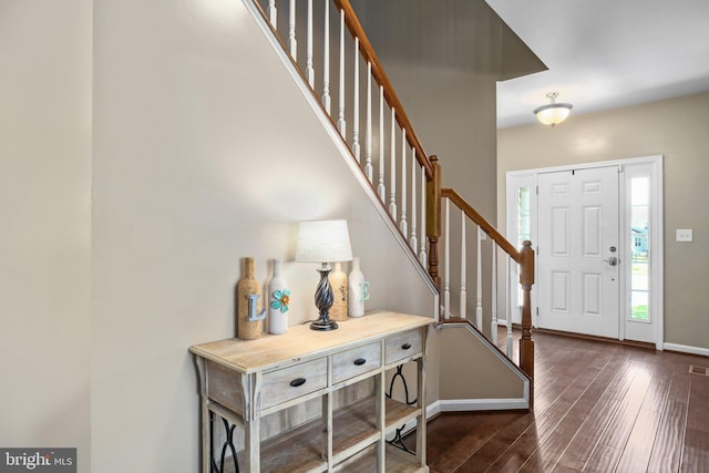 entryway featuring dark wood-style flooring, visible vents, baseboards, and stairs