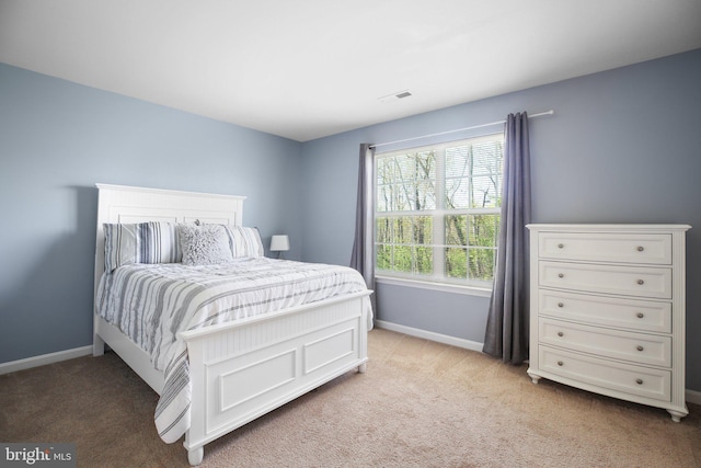 bedroom with light carpet, visible vents, and baseboards