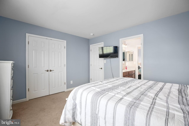 carpeted bedroom featuring a closet, baseboards, and ensuite bathroom