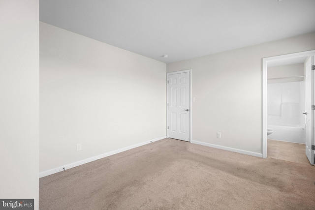 unfurnished bedroom featuring carpet flooring, baseboards, and connected bathroom