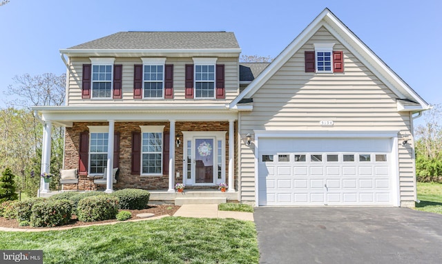 traditional-style house with aphalt driveway, a porch, stone siding, and a shingled roof