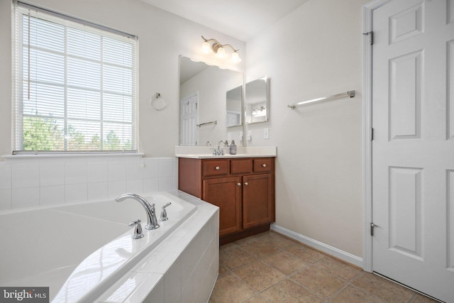 bathroom featuring baseboards, vanity, and a garden tub
