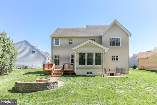 rear view of property with an outdoor fire pit, a deck, and a lawn