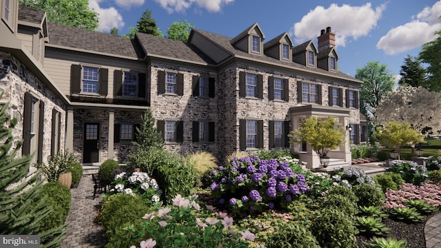 back of property with stone siding and a chimney