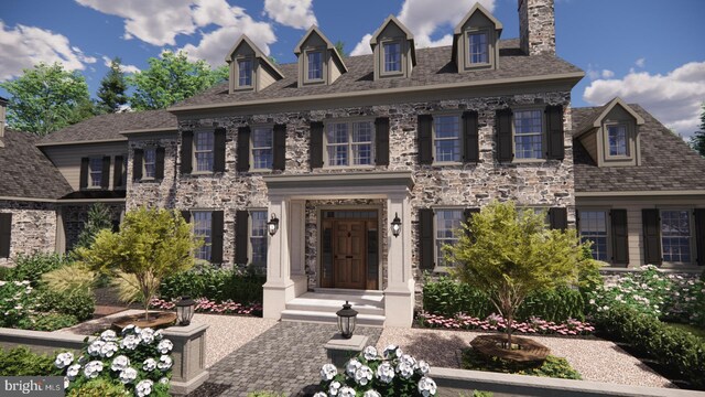 colonial house featuring a chimney and stone siding
