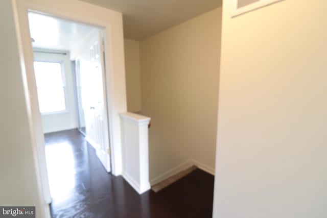 hall with an upstairs landing, dark wood-style floors, and baseboards