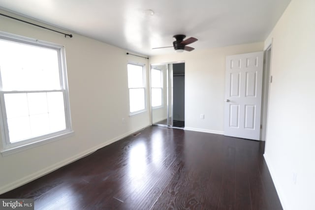 unfurnished bedroom with baseboards and dark wood finished floors