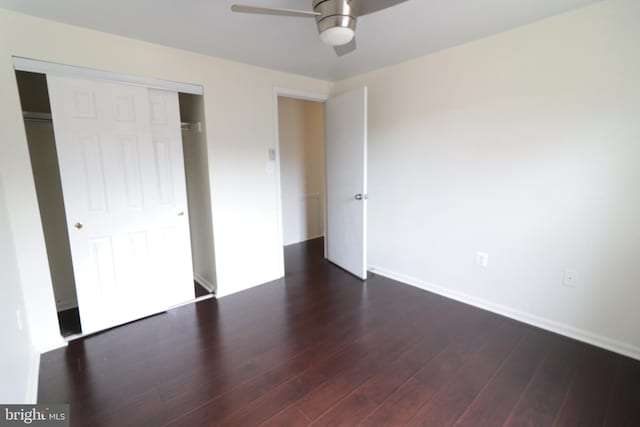 unfurnished bedroom with baseboards, a closet, ceiling fan, and dark wood-type flooring