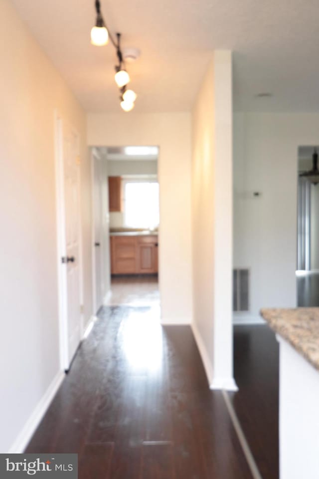 hall with dark wood-style floors and baseboards