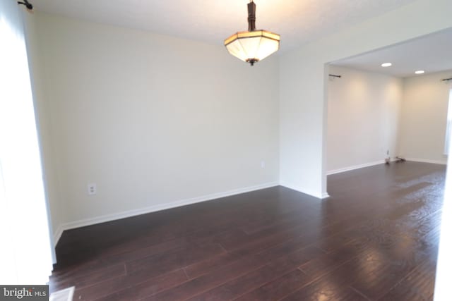 unfurnished room with baseboards, recessed lighting, and dark wood finished floors