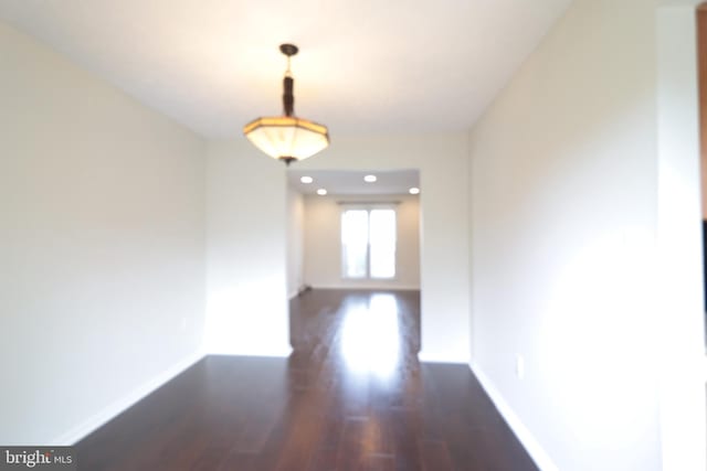 hall with baseboards and wood finished floors