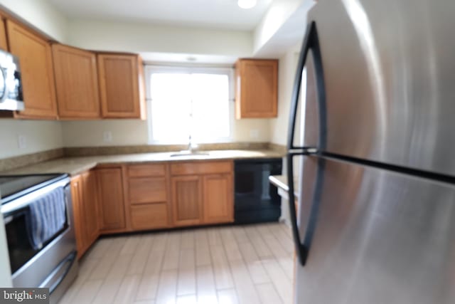 kitchen with light countertops, freestanding refrigerator, brown cabinets, dishwashing machine, and range