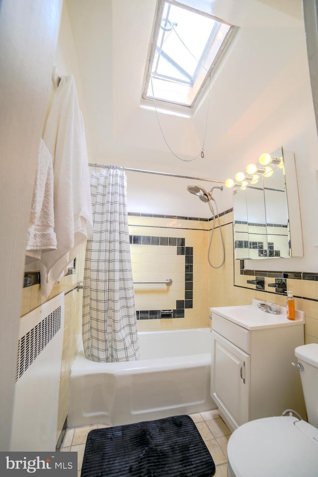 bathroom with toilet, shower / bath combo with shower curtain, a skylight, vanity, and radiator heating unit
