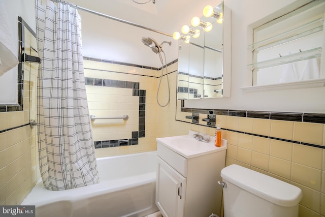 bathroom featuring toilet, vanity, tile walls, and shower / tub combo