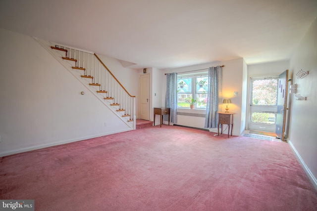 unfurnished living room with carpet flooring, stairway, and baseboards