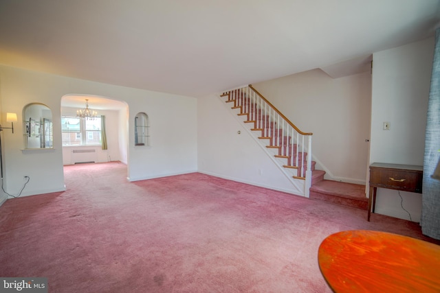 unfurnished living room featuring arched walkways, stairs, a chandelier, and carpet floors