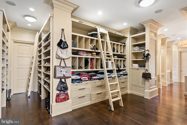 walk in closet with decorative columns and wood finished floors